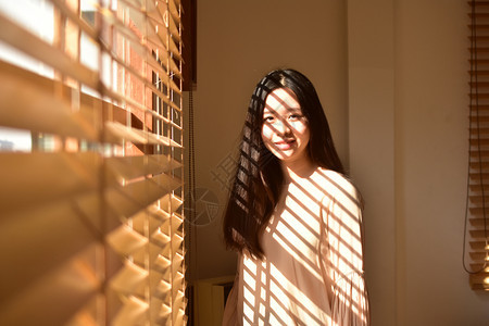 人们年轻美貌女站在窗边年轻的淑女图片