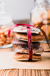 曲奇饼很少木头圣诞快乐在木桌边的罐子上夹着背景画像方向上的甜点来做一些红丝带的姜饼图片
