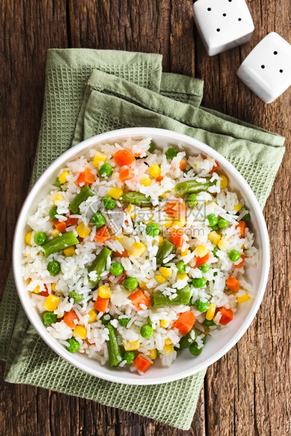 盘子与多彩蔬菜洋葱胡萝卜绿豆玉米白碗中的青豆混杂在一起的煮白大米用蔬菜对面的稻米拍照素食主义者甜的图片