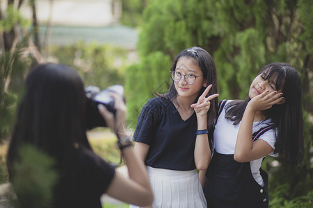 手持Dslr相机的三名亚洲青少年装扮成时模特数码单反学校朋友图片