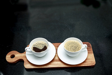 新鲜的两杯咖啡在木板上和店的角度拍摄制作者白色的图片