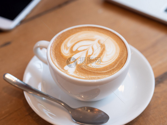 勺子咖啡厅的木制桌子上一个白色杯中的咖啡拿铁早晨液体图片