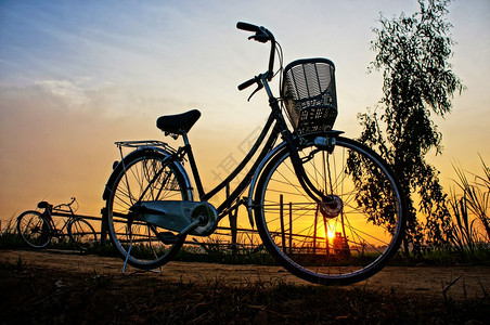 美丽的自然景观印有太阳和月亮两辆自行车在农村日出时的周光和脚影乡村的颜色印象图片