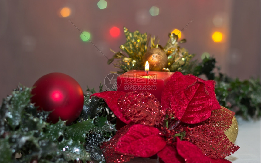 礼物庆祝一个明亮的红辣椒奶油与圣诞节蜡烛和Holly小玩意图片