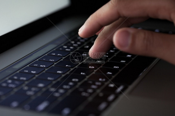间谍商业黑客攻击晚上在键盘计算机工作时打字的密闭手指键盘图片