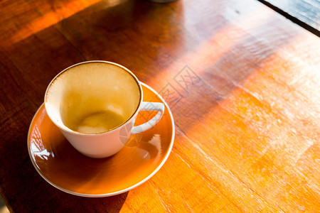 颜色清晨阳光下木桌空咖啡杯拿铁木制的图片