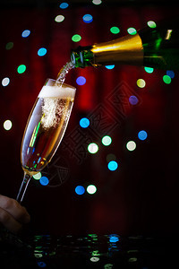 长笛庆祝新年和圣诞香槟的理念从瓶子上倒入玻璃里从瓶子上倒进玻璃里杯子上加满了香槟喜庆的派对图片