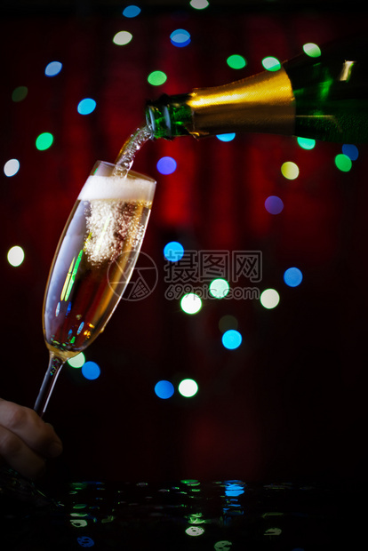 长笛庆祝新年和圣诞香槟的理念从瓶子上倒入玻璃里从瓶子上倒进玻璃里杯子上加满了香槟喜庆的派对图片