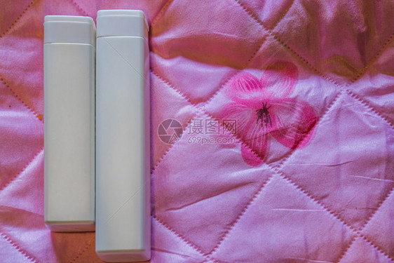 粉色床垫上的空白包装瓶图片