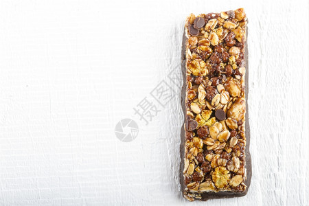 早餐白色木制背景的巧克力Muesli酒吧健康的粮食图片