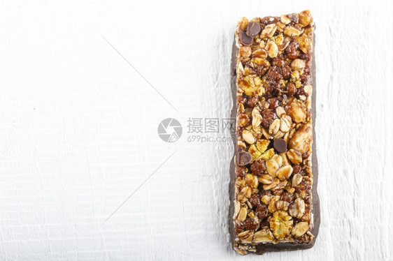 早餐白色木制背景的巧克力Muesli酒吧健康的粮食图片