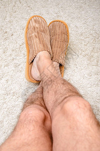 58皮卡头发一个有毛腿的男人穿着温暖拖鞋在羊毛地毯上用脚放松毛茸图片