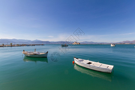 希腊Nafplion背景的摩尔传统渔船轻型和Bourtzi堡垒希腊广角历史地中海停泊图片