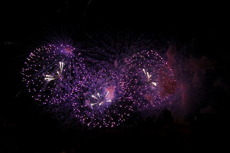 庆祝日彩色的烟花在夜黑天空背景中闪耀喜庆的周年纪念日星图片