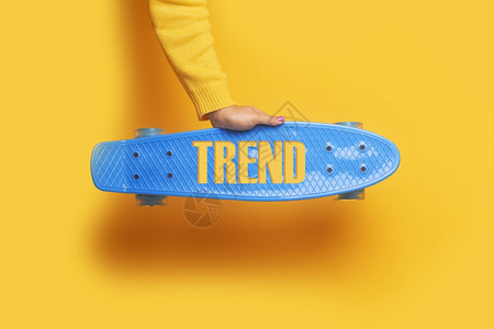 户外现代的日落蓝色滑板在黄背景上随手趋势登记在滑冰上面图片