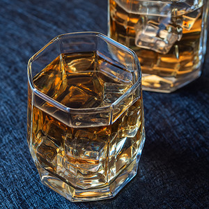 昂贵的夜生活眼镜两杯威士忌蓝色背景的冰上加我正要喝两杯威士忌图片