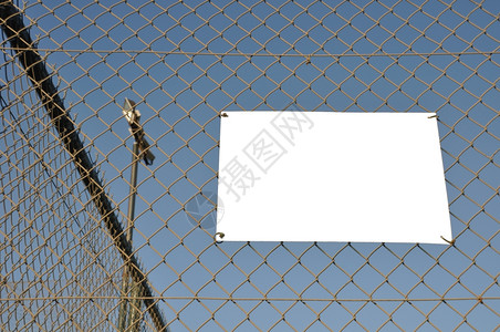 挂在体育法庭铁丝网围栏上的空标牌栅对角线横幅图片