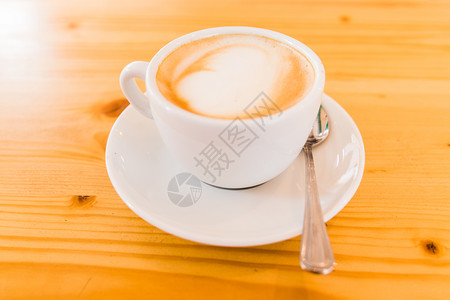 拿铁咖啡艺术质地早餐木制桌上的白卡布奇诺马克杯背景