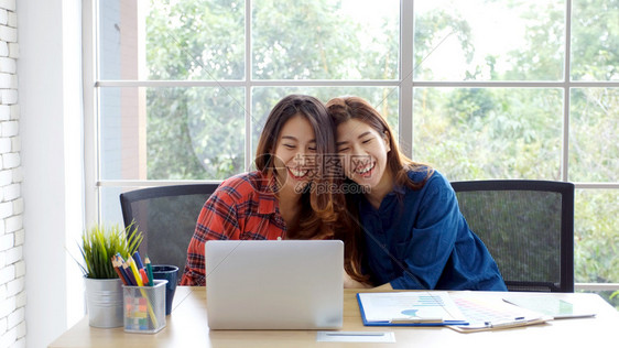 女士片刻学习两名在家庭办公室用笔记本电脑工作情绪快乐在家工作小企业办公室临时生活方式概念的年轻女青她们有2名青女图片