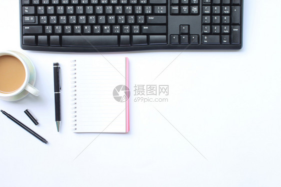 多于办公室白桌子上的笔记本支架键盘和咖啡杯放在办公室的白桌上并在你工作中复制了这一概念的空间工作区一种图片