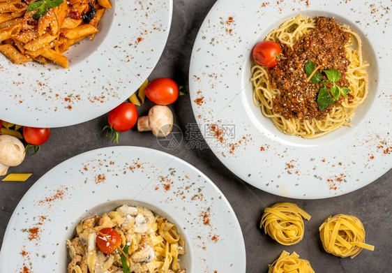面粉和薄意大利西红柿和黑石桌上的烤肉结盘子一顿饭图片