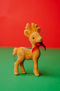 庆典传统十二月绿色桌上的驯鹿Christams装饰用生动红色背景喜剧日贺卡和复印空间图片