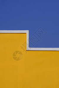 复古的之字形建筑和背景设计概念垂直框架的空黄色水泥建筑墙对蓝清晰天空的垂直结构框和背景设计概念中的空黄色水泥建筑壁的几何模式户外图片