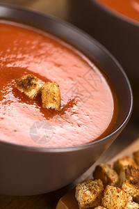 全麦新鲜自制番茄汤上面有全草红包在棕色碗里黑木上选择焦点聚在汤上的前面蔬菜正图片
