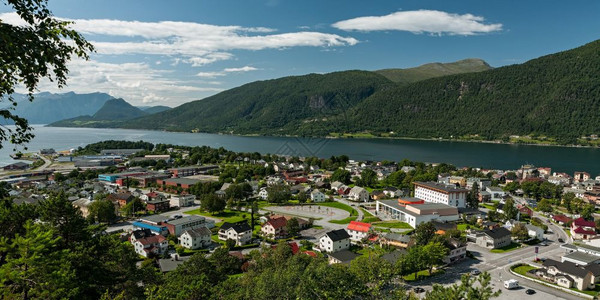 在阳光明媚的天空下在Romsdalsfjorden对挪威的Andalsnes市的全景在下面罗姆斯达尔峡湾绿色图片