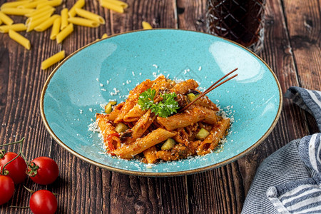 午餐意大利面番茄酱的潘意西红柿装饰用木制背景的鹦鹉一顿饭图片