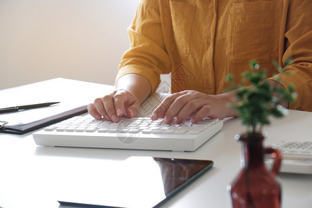 键盘白色的女在办公室打字时用手贴近工作场所图片