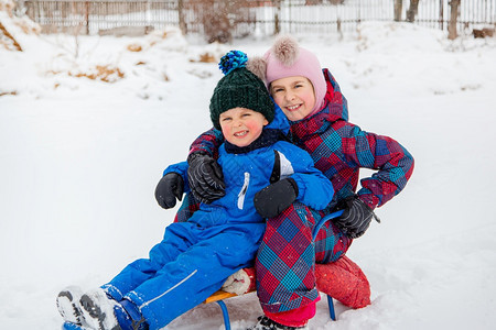 寒冷的快乐男孩和女在冬天从山上拉雪橇冬季户外运动会寒假快乐的男孩和女在冬天从山上拉雪橇冬季户外运动会活冷冻图片