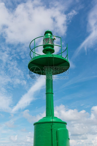 水运输蓝色的小绿金属灯塔蓝天和彩云在背景中图片