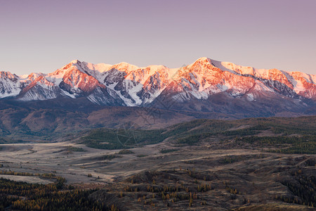 顶峰下雪的蓝色山丘旅游景点自然美观的风景以及清晨旅程中雪峰和河谷的景象图片