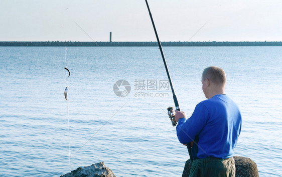 海边钓鱼的男子图片