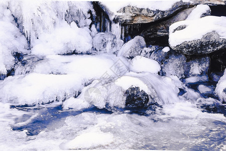 景观冰雪下冬山河水冻成冰柱图片