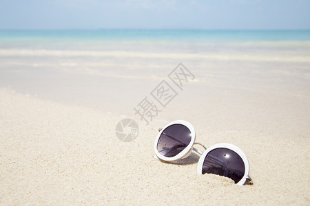夏天蓝海沙滩上的太阳镜眼采取蓝色的图片