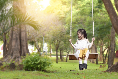 愉快小女孩在夏花园的游乐场玩耍在暖和阳光明媚的户外积极俏皮图片