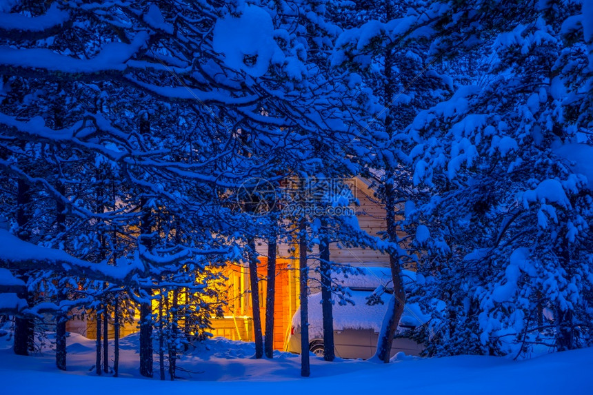 在雪覆盖的树枝中一个木屋和汽车图片