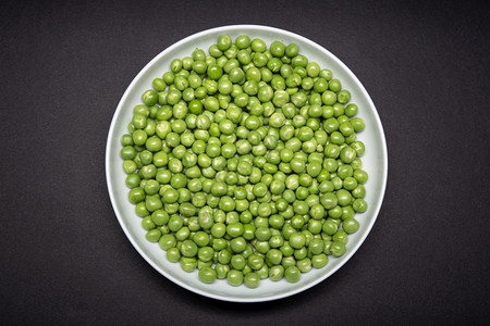 素食主义者一种黑色的底青豌豆被隔绝在一盘新鲜青豆上图片素材