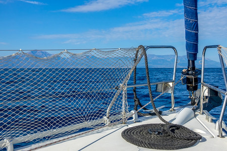 丰富多彩的游艇在宁静海中航行游艇弓绳子和蓝天的云帆船游艇和黑绳阳光夏天图片