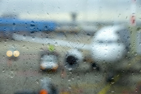 在雨季的现代机场通过RainyWeather的雾化玻璃现代机场查看停靠的飞机液体旅行假期图片