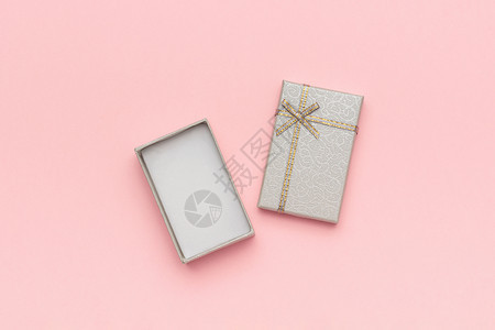弓空白的打开灰色礼品盒在最小样式的粉色柔和背景上带有蝴蝶结顶部视图复制空间模型打开灰色礼品盒在最小样式的粉色柔和背景上带有蝴蝶结图片
