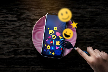 在数字世界桌面最佳视图中使用叉口吃早餐的名词概念相片人与社会媒体Emoji在移动电话线例行日常生活方式和技术上的Emoji图标网图片