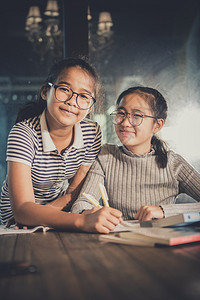 两个快乐的亚裔青少年在学校课堂习快乐的情绪幸福感趣坐着女士图片