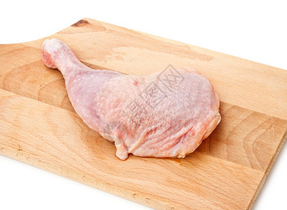 切板上铺着的新鲜鸡大腿烹饪鼓槌生的图片