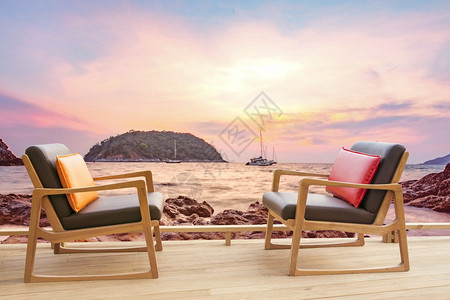 户外日落海观露天平台上的木椅子制图片