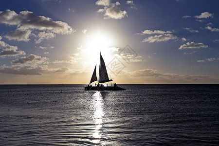 日落时在海上航行的帆船图片