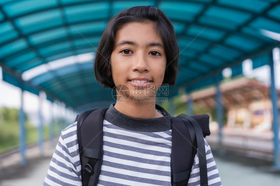 后部自由愉快亚裔女孩带着背包走去上学回校概念的图片