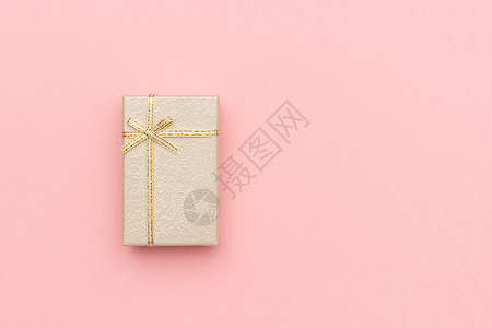 惊喜天纸Beige礼品盒在粉色糊面背景上用箭头在粉红色画面背景上鞠躬以最小的风格展示TopView复制空间模拟图片